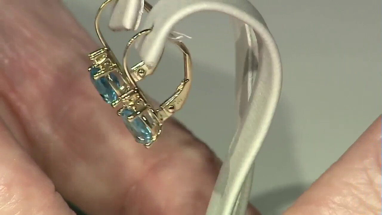 Video Gouden oorbellen met Zwitsers-blauwe topaasstenen